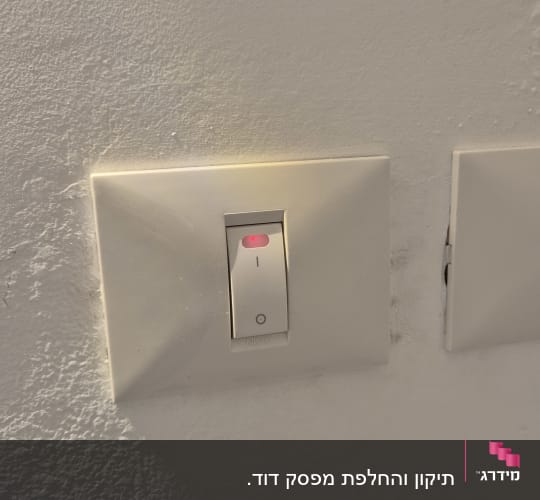 מתג חשמלי על קיר עם תאורה